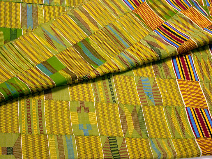 Folded Asante kente cloth in gold, green and blue, woven in narrow strips