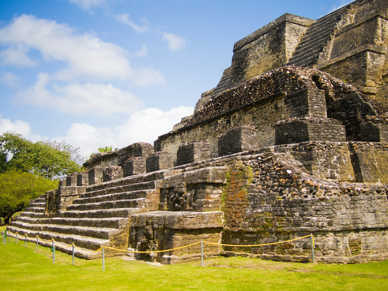 Weathered stone Maya temple steps under a blue sky in Belize